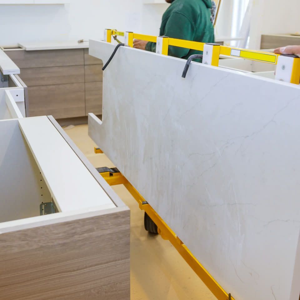 Installers setting a white countertop on new base cabinets